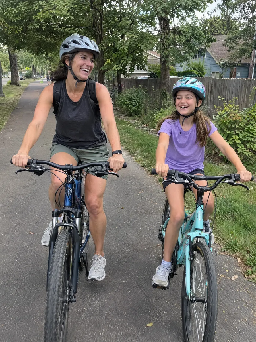 Cycling with her daughter on a neighborhood bike path