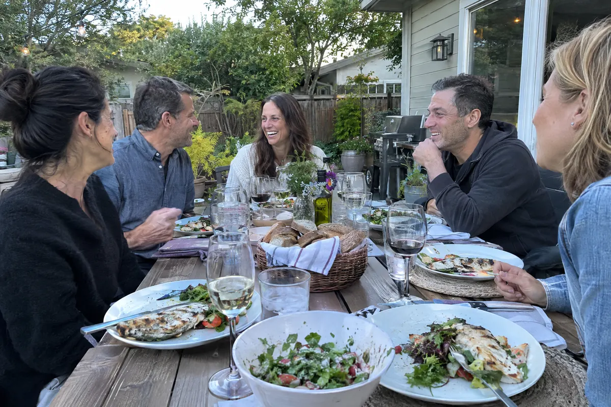 Friends sharing dinner on a backyard patio