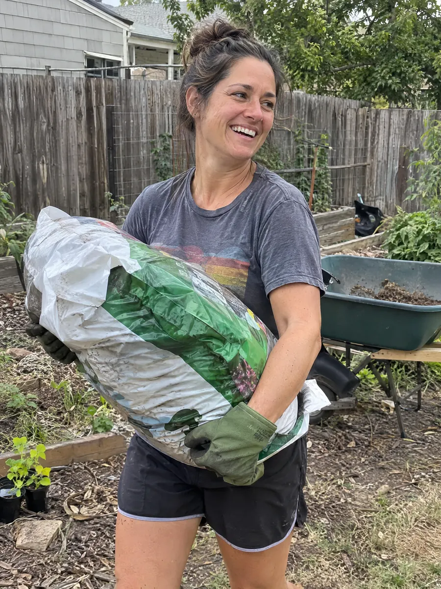 Carrying a heavy bag of soil across the yard