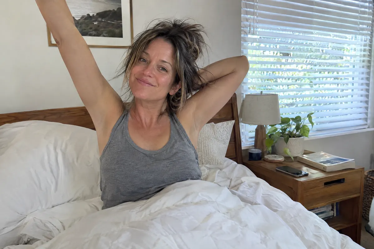 A woman sitting up in bed, rested, in the morning