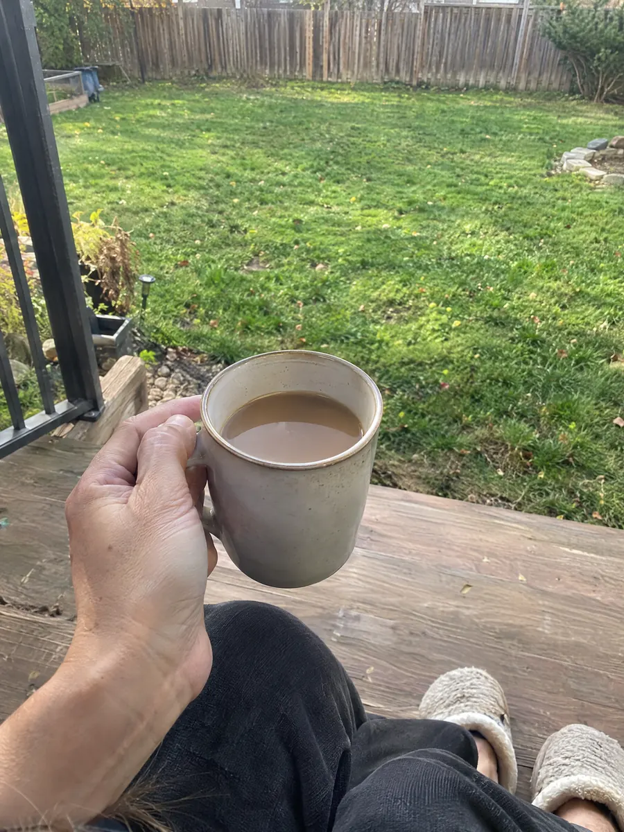 A mug of coffee on the back porch steps in the morning